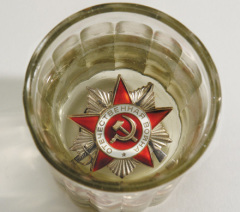 Фото: Орден Отечественной Войны в граненом стакане с водкой.